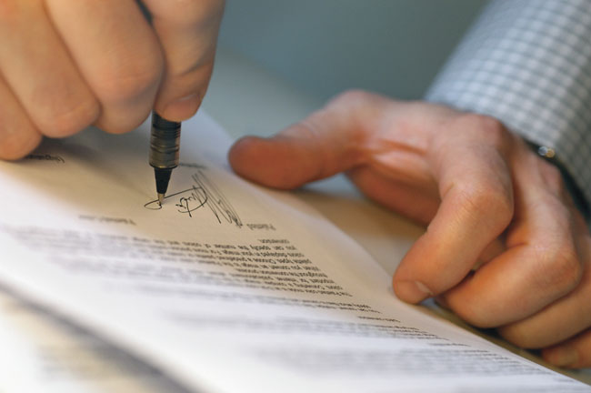 Man's Hands Signing Document - Contabilidade em Brasília | Vértice Contadores e Associados S/S Ltda.