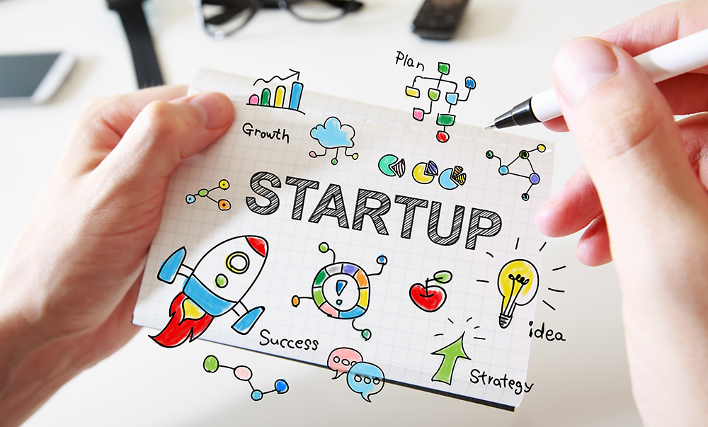 Mans Hand Drawing Startup Concept On Notebook - Contabilidade em Brasília | Vértice Contadores e Associados S/S Ltda.